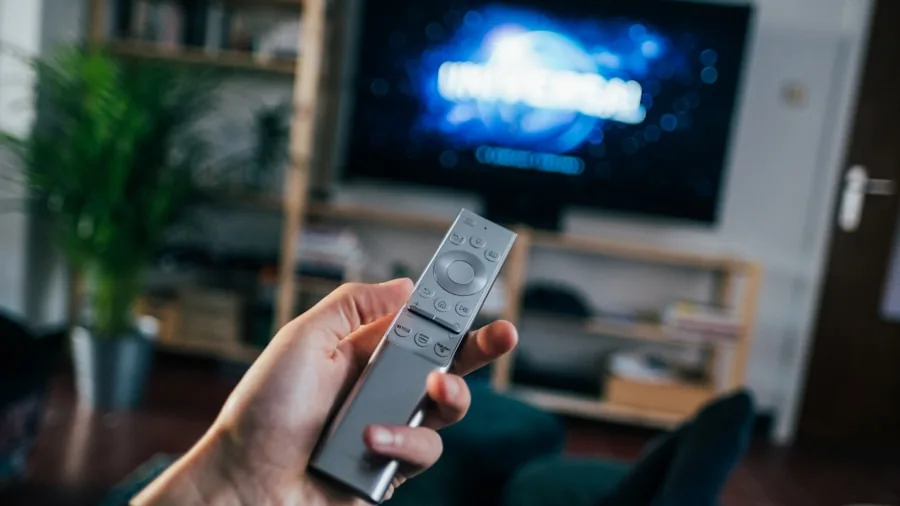 Person sitting close to small television screen, examining picture quality and resolution details