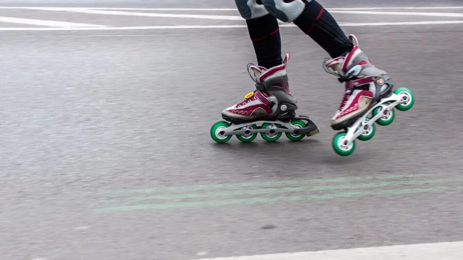Person sitting down adjusting and fitting roller skates to check sizing and comfort