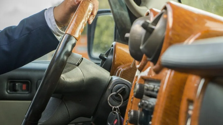 Person sitting in car comparing different automotive technology devices and reviewing options