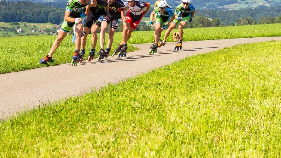 Person sitting outdoors checking the fit and comfort of inline skates on their feet