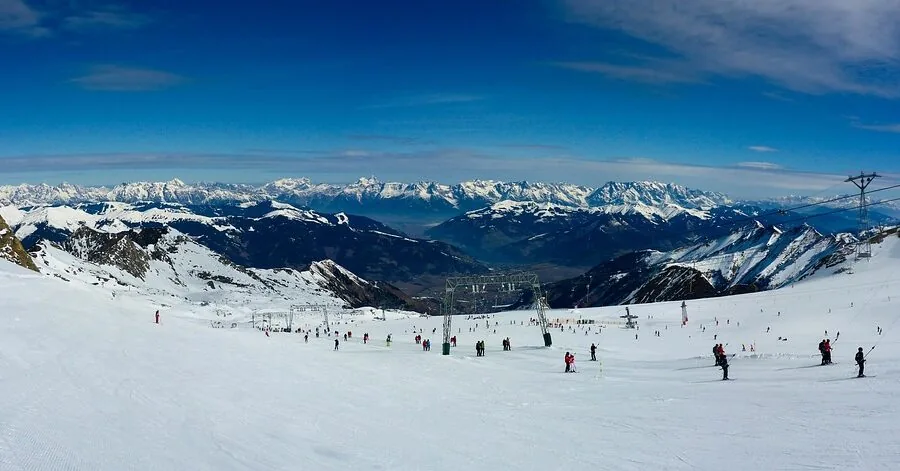 Person skiing down a snowy mountain slope wearing waterproof winter gear