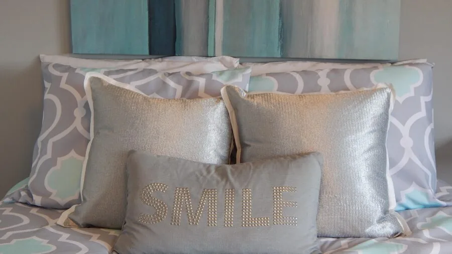Person sleeping comfortably on light colored sheets in a bright, airy bedroom during summer