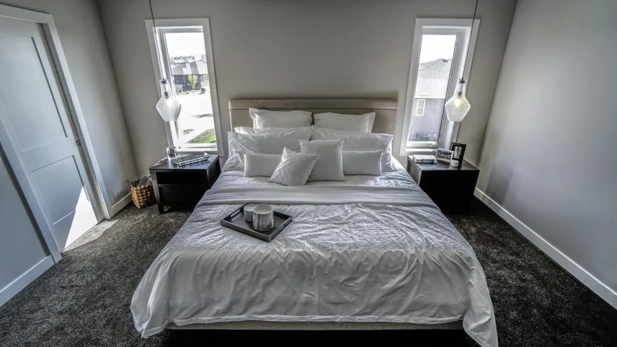 Person sleeping peacefully in clean bedroom with white bedding, representing allergen-free sleep environment
