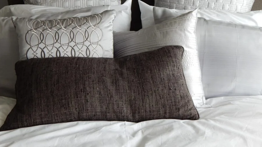 Person sleeping peacefully on comfortable bedding in natural bedroom light