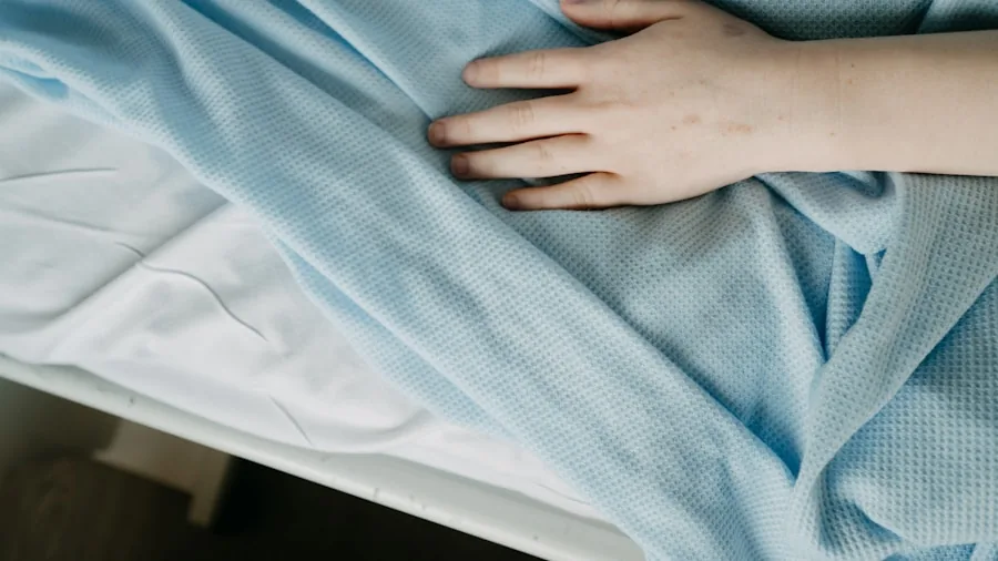 Person smoothing fresh cotton sheets on bed in bright bedroom