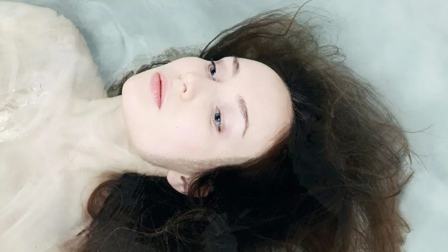 Person soaking feet in warm water with natural ingredients for relaxation and self-care wellness