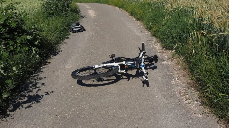 Person steadying bike pump base while inflating tire outdoors