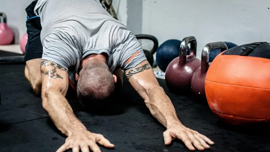 Person stretching hamstring and glute muscles after workout for recovery and muscle care