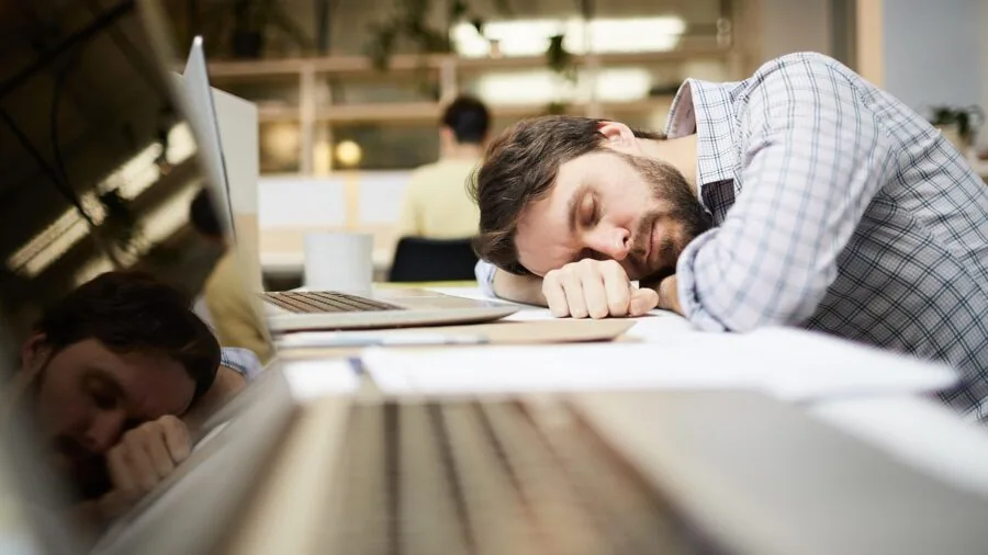 Person taking a break outdoors, wiping forehead after physical exertion in warm conditions