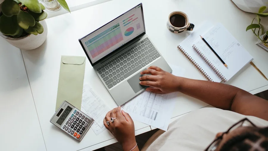 Person thoughtfully planning budget and finances while working at desk with laptop