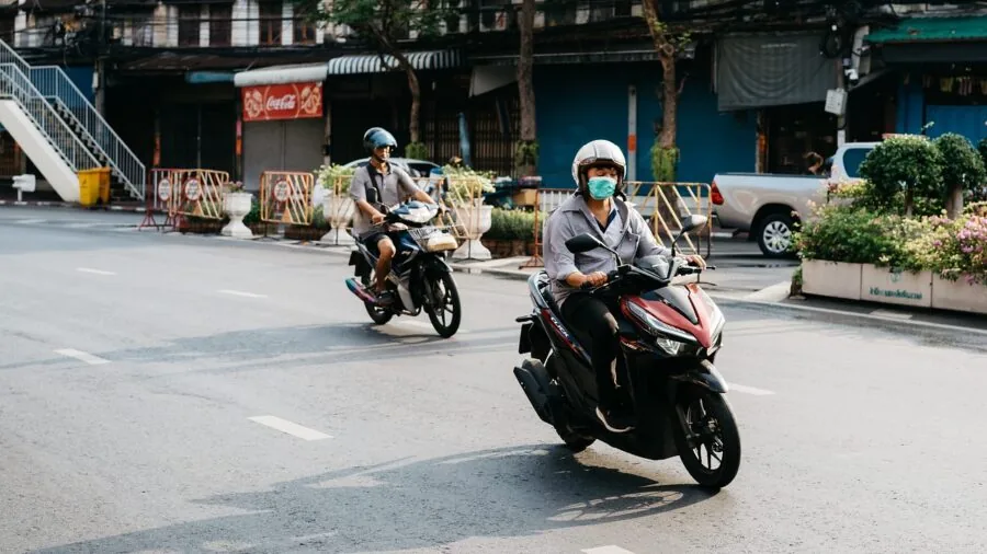 Person trying on motorcycle boots while seated, checking fit and comfort before riding