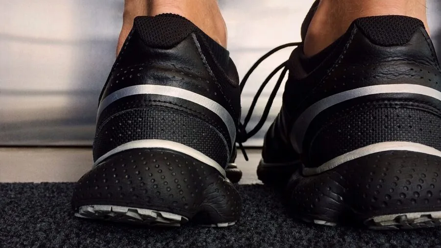 Person trying on running shoes while sitting, checking proper fit and comfort during shoe selection