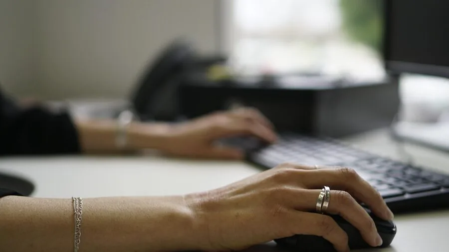 Person typing intensely on keyboard with focused expression during gaming session