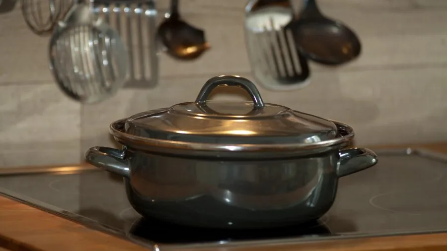 Person using a ladle while cooking various dishes in a home kitchen