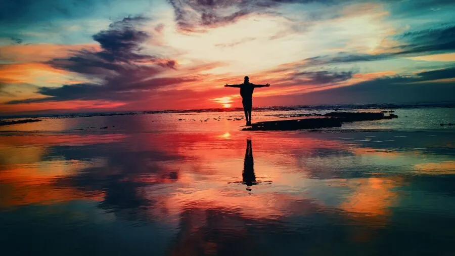 Person using binoculars to observe wildlife during low-light dusk conditions in natural landscape