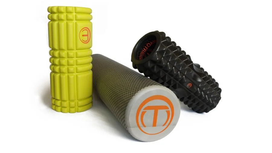 Person using foam roller on leg during home workout routine for muscle recovery and therapy
