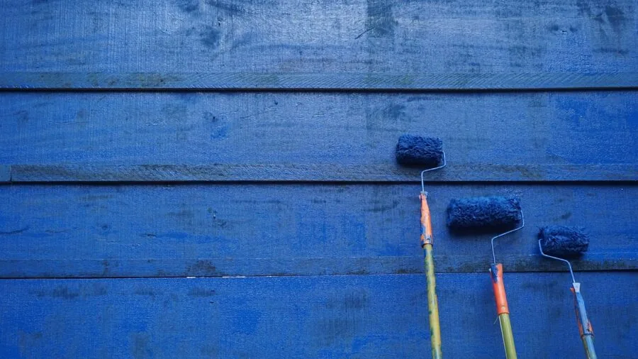 Person using paint roller to paint interior wall during home renovation project