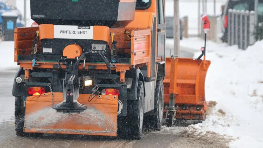 Person using proper technique while shoveling snow from driveway during winter storm