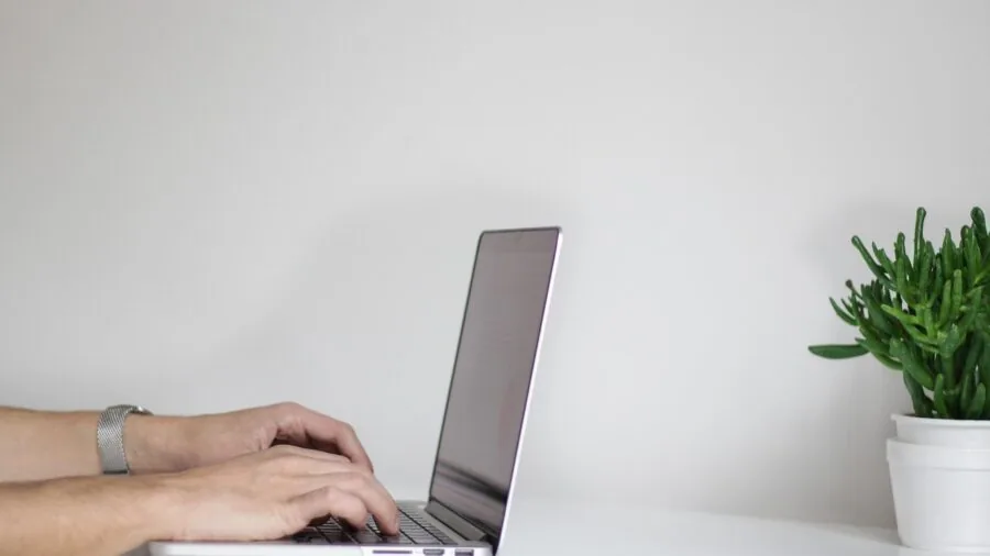 Person using smartphone near bedside lamp with charging ports in contemporary bedroom setting