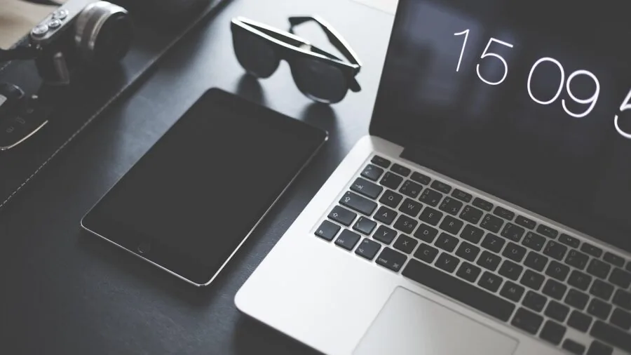 Person using tablet on sturdy stand at wooden desk for work