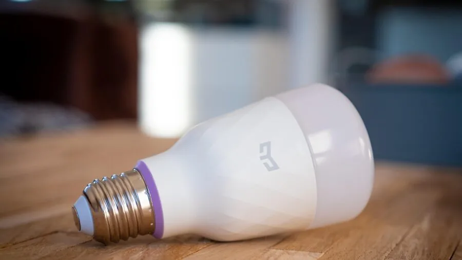 Person using voice assistant to control home lighting from smartphone in modern living room