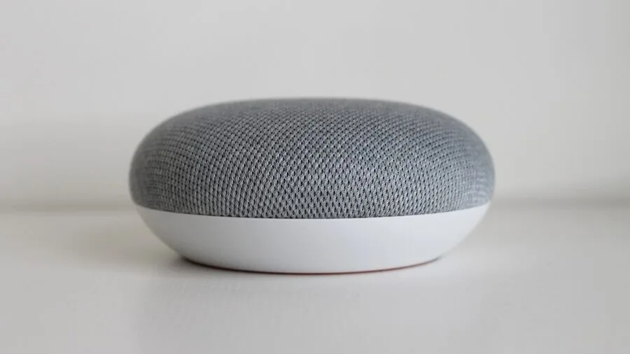 Person using voice-controlled smart home device in modern living room with connected technology setup