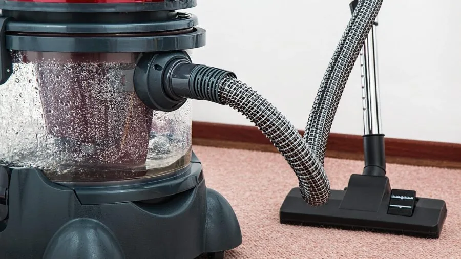 Person vacuuming hardwood floor in bright modern apartment living room