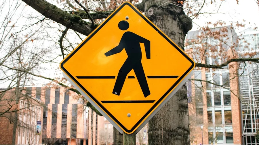 Person walking in wet corridor looking at tall caution sign ahead