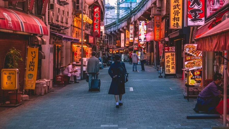 Person walking through a vibrant city street with shopping bags, exploring local shops and streets during daytime travel