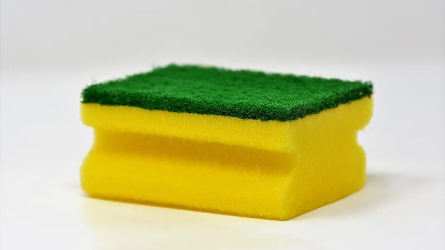 Person washing car with soapy water and sponge, demonstrating proper washing technique