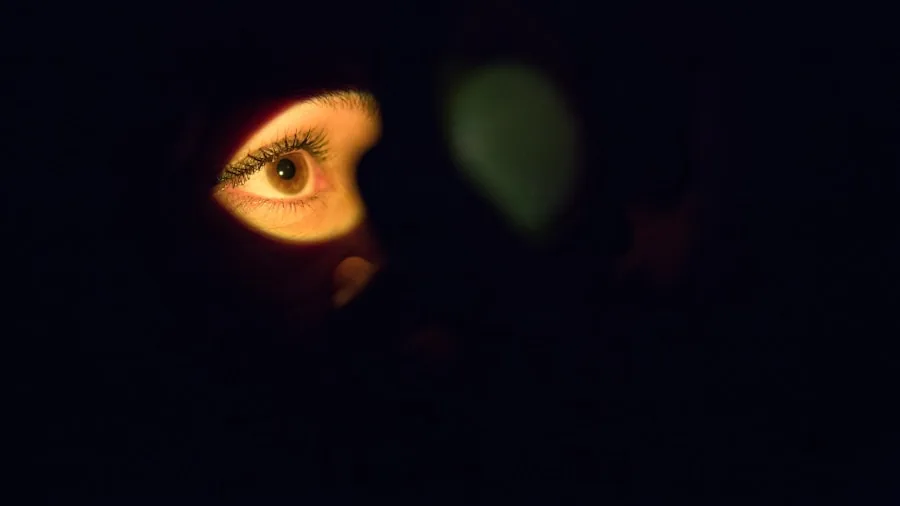 Person watching high contrast video on bright display in dimly lit living room