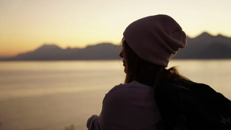 Person wearing a knit beanie while enjoying outdoor winter activities in natural daylight