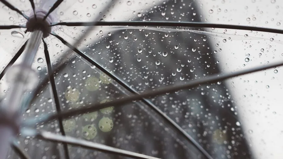 Person wearing backpack in rainy weather demonstrating water resistance and durability