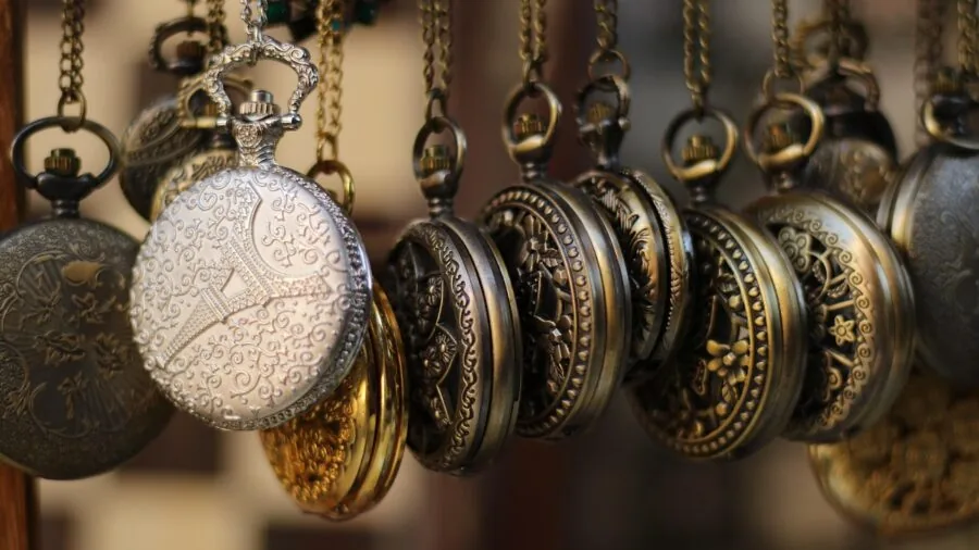 Person wearing classic pocket watch chain attached to vest pocket in natural daylight