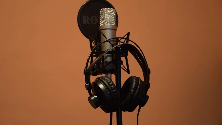 Person wearing headphones at a desk during audio recording session, monitoring sound in real-time