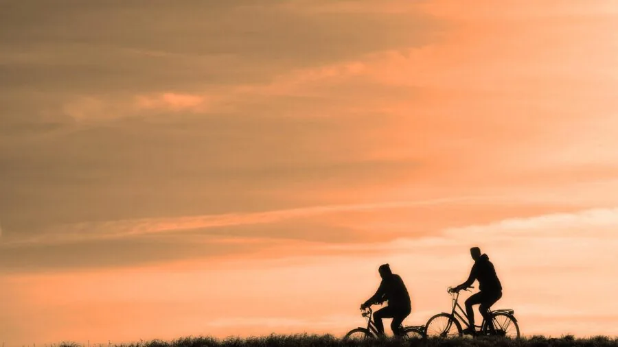 Person wearing helmet while riding bike on outdoor trail, emphasizing safety gear importance