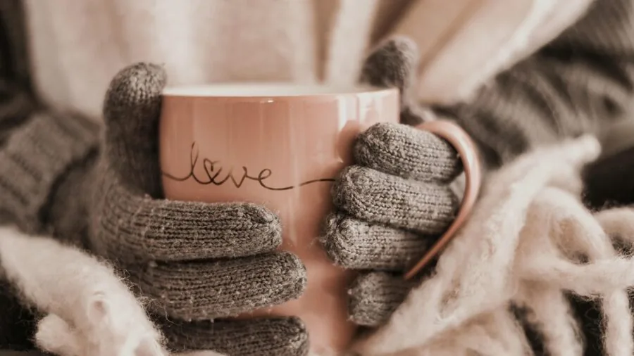 Person wearing plush slippers relaxing at home near a window on a cold day