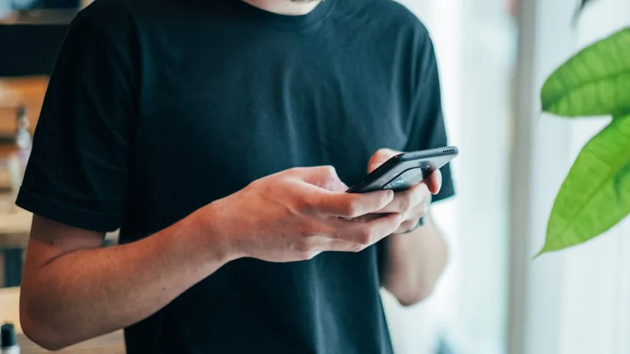 Person wearing wireless earbuds while checking smartphone, representing ecosystem compatibility between devices