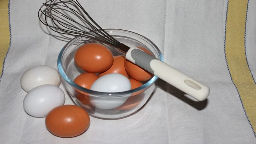Person whisking ingredients in a mixing bowl during food preparation in a home kitchen