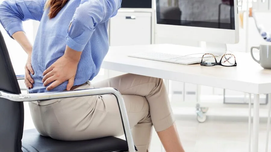 Person working at desk with proper back support and ergonomic seating posture