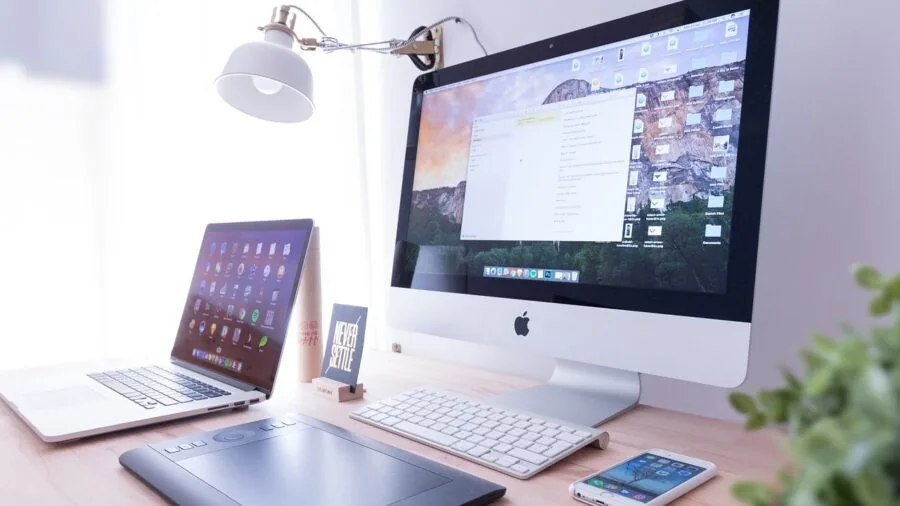 Person working at desk with tablet and wireless keyboard in modern home office setting
