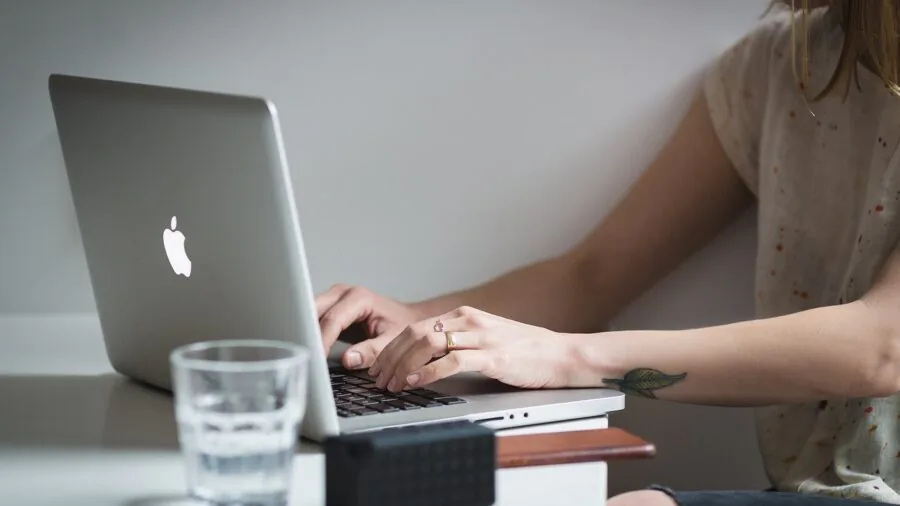 Person working at desk with water bottle nearby, demonstrating moisture-resistant workspace setup