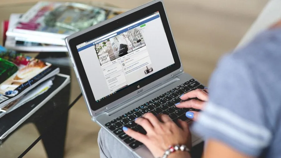 Person working at laptop with focused keyboard typing in modern workspace environment