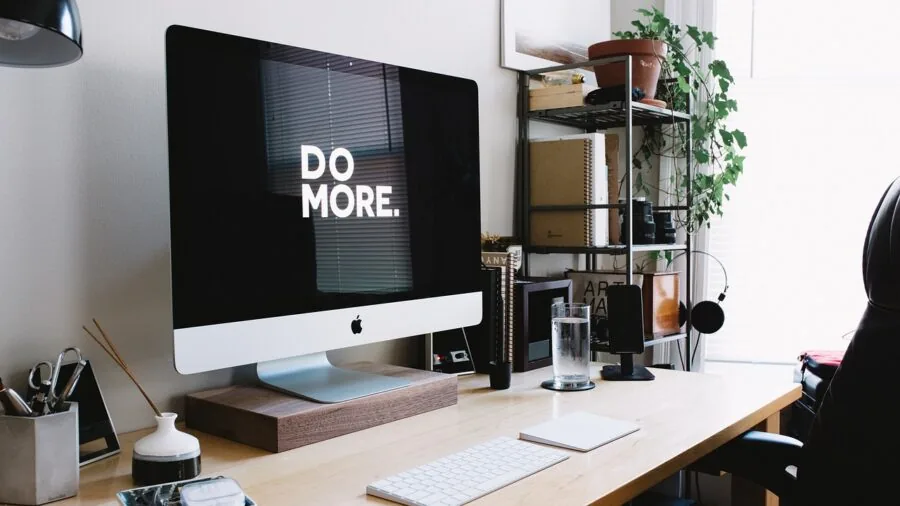 Person working at organized desk with monitor in home office environment