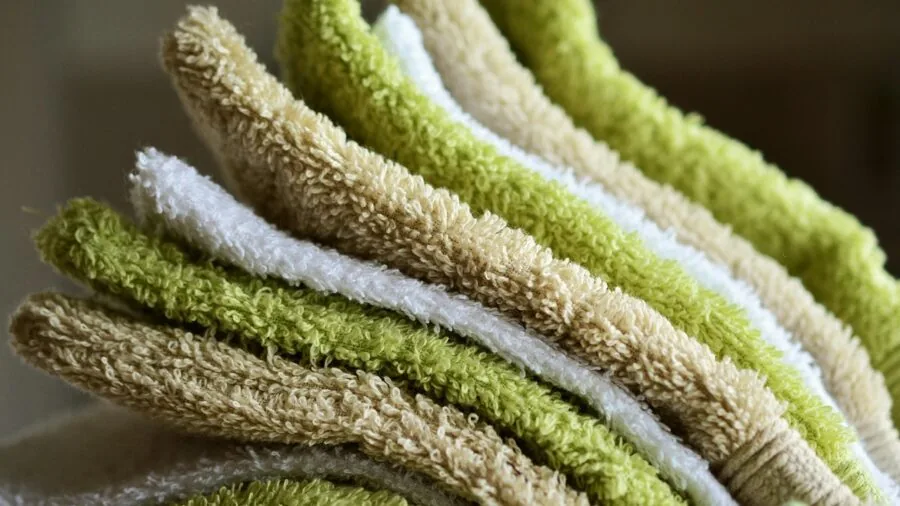 Person wrapping in soft absorbent terry cloth bathrobe after shower, demonstrating moisture-wicking comfort
