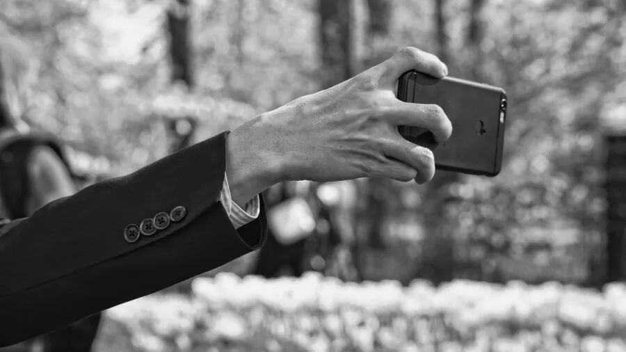 Person's hand adjusting phone grip angle while holding smartphone in landscape position
