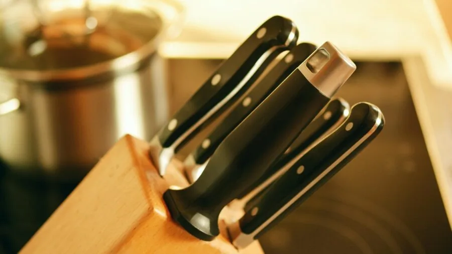 Person's hands adjusting control dial on kitchen appliance with focused expression