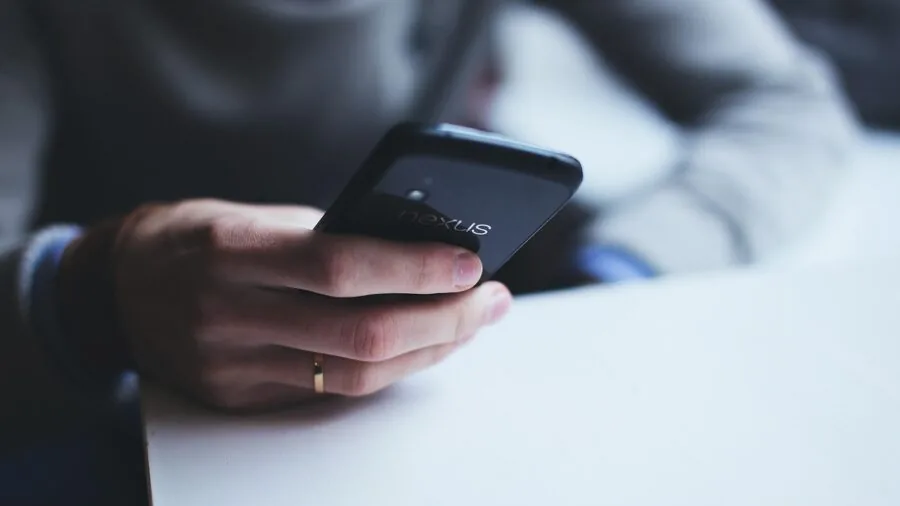 Person's hands holding a lightweight portable music device, examining build quality and durability