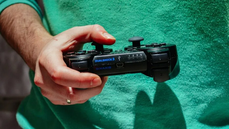 Person's hands holding gaming controller during intense gameplay session