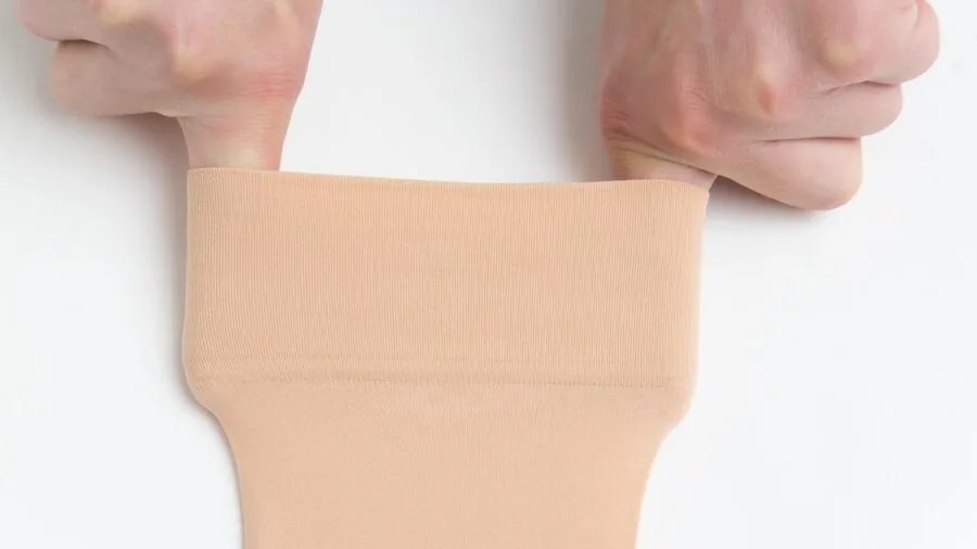 Person's hands stretching elastic material to test flexibility and fit during product selection